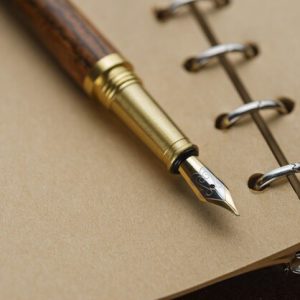 brown-fountain-pen-on-a-notebook-with-yellow-pages_120871-483